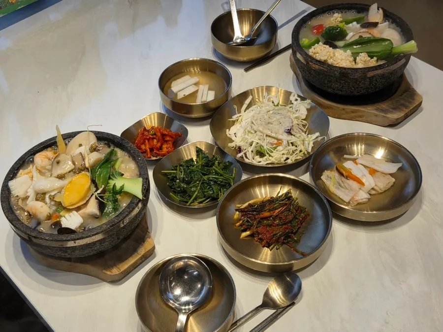 Server pouring scorched rice and broth into the stone pot