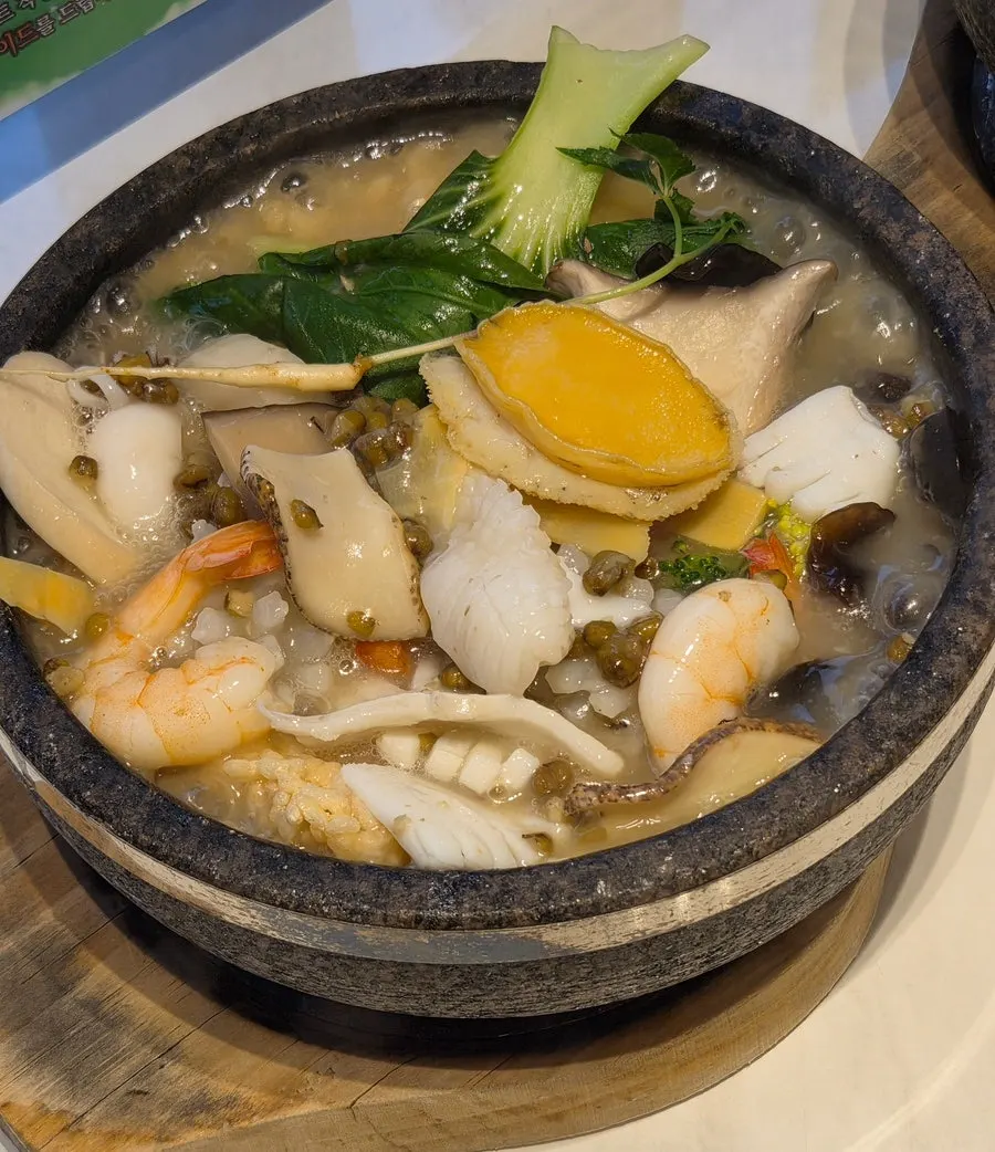 Table loaded with two bowls of nurungjitang and side dishes