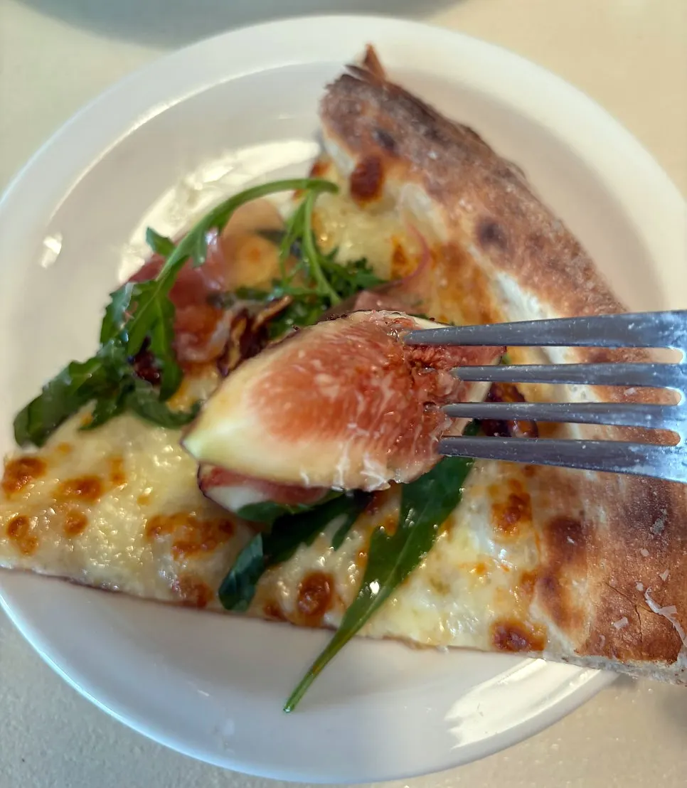 Holding up a slice of pizza