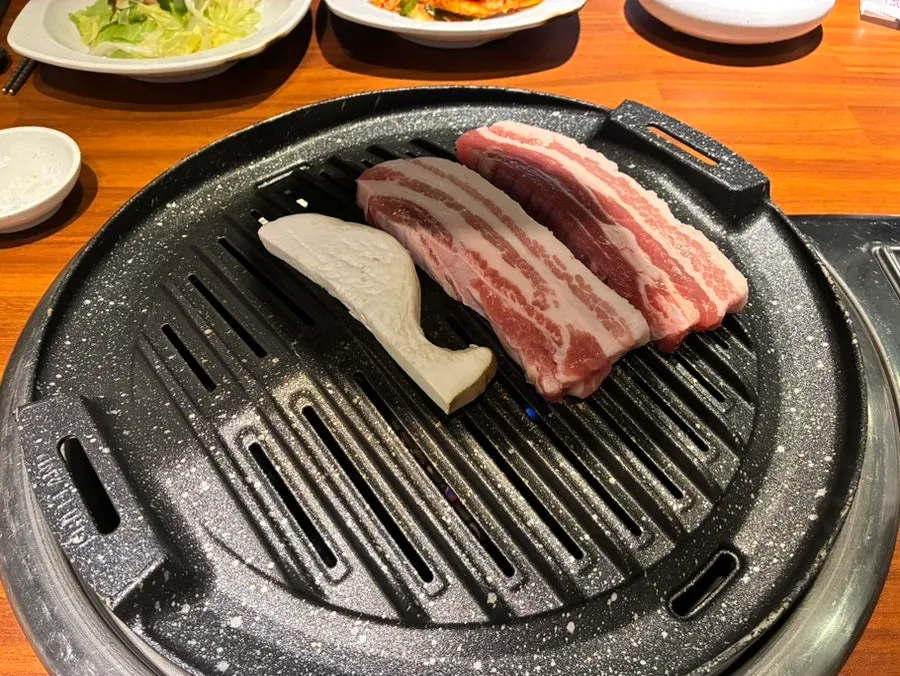 불판에 올린 삼겹살과 버섯
