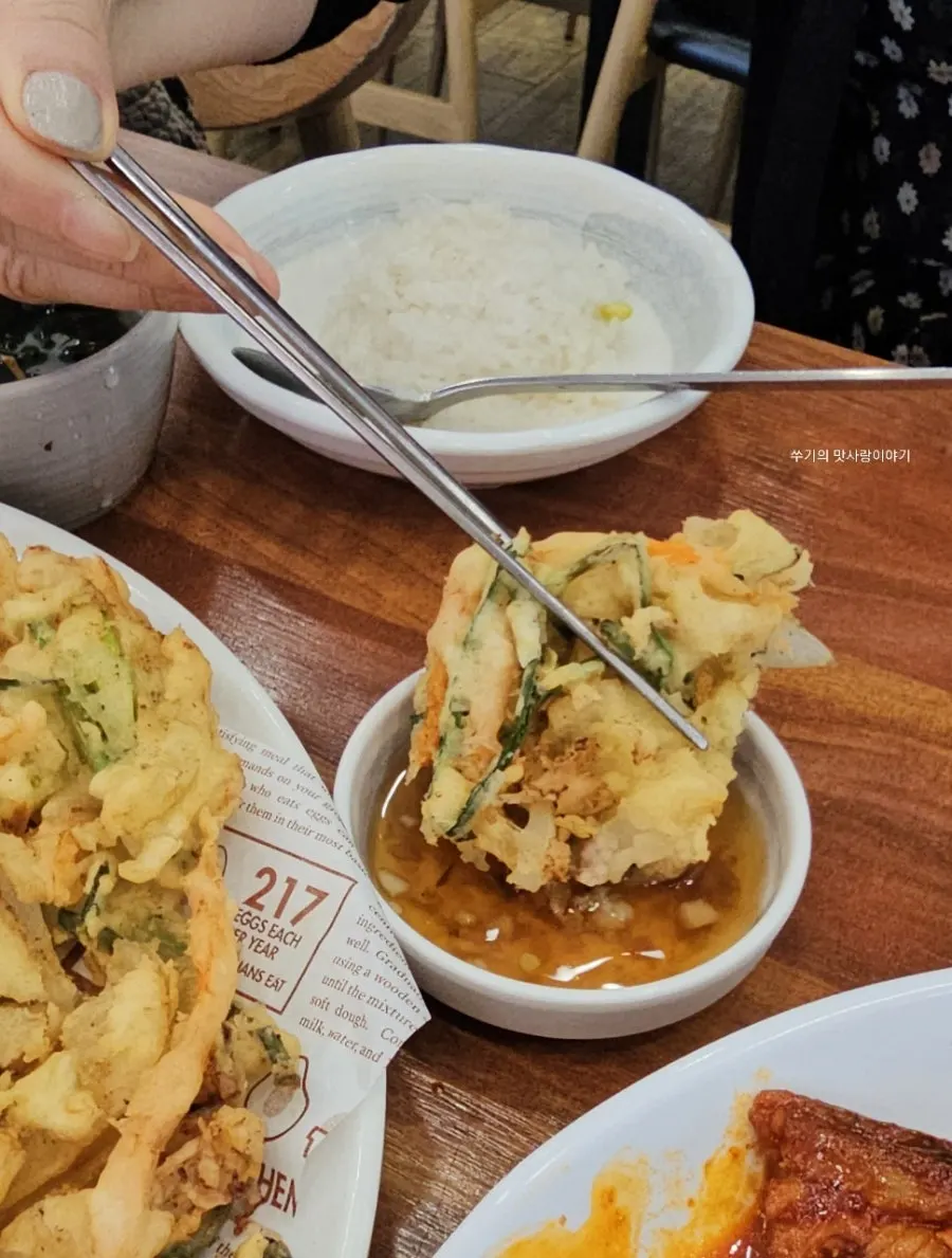 A piece of seafood pancake dipped in sauce