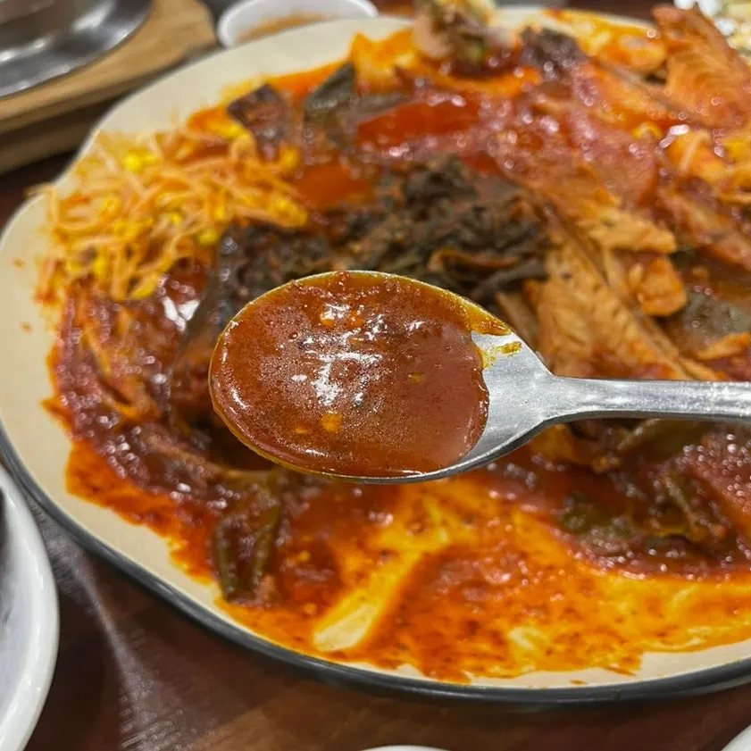 A bite of rice topped with thick flakes of braised pollock