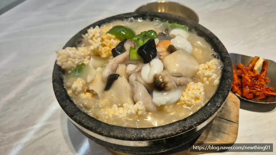 Pouring seafood sauce over nurungji in an earthenware pot