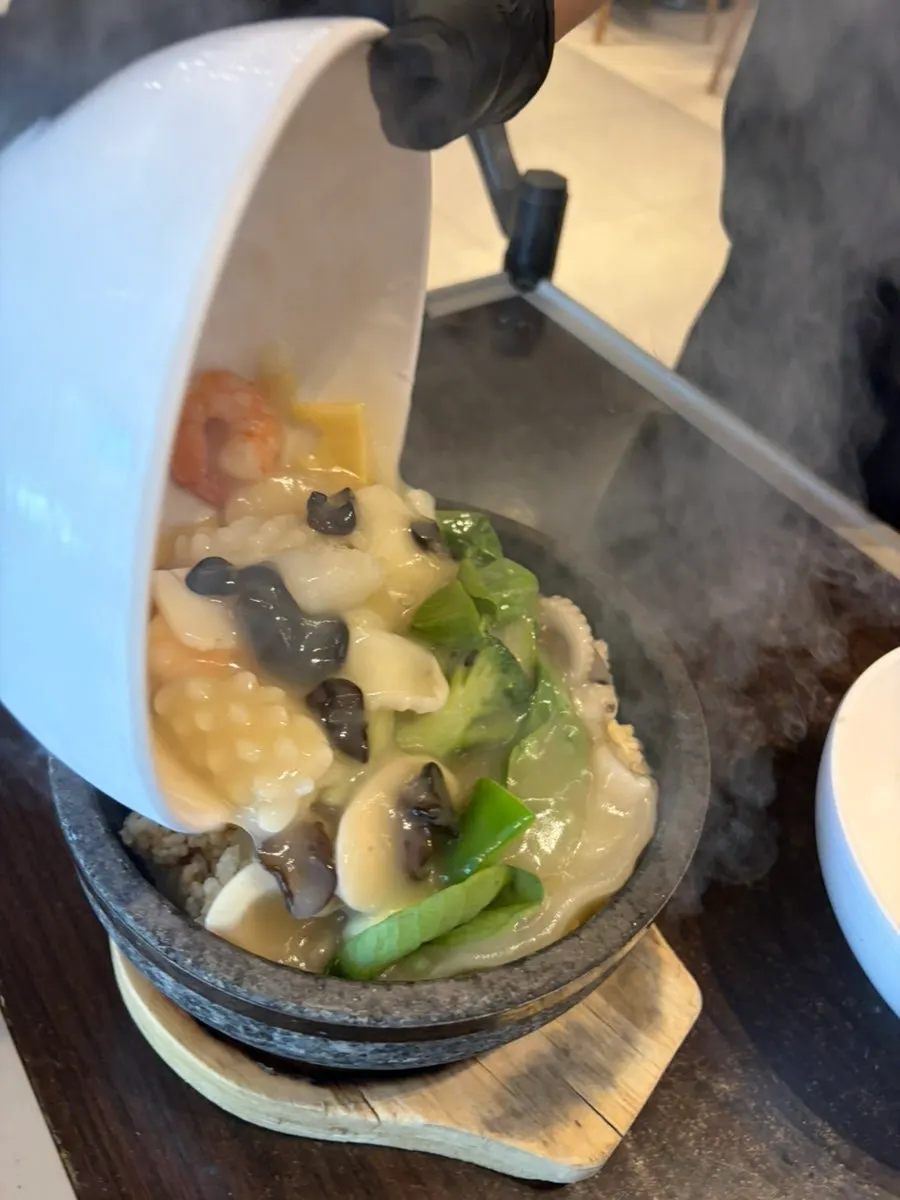 Pouring the scorched-rice soup broth into the pot