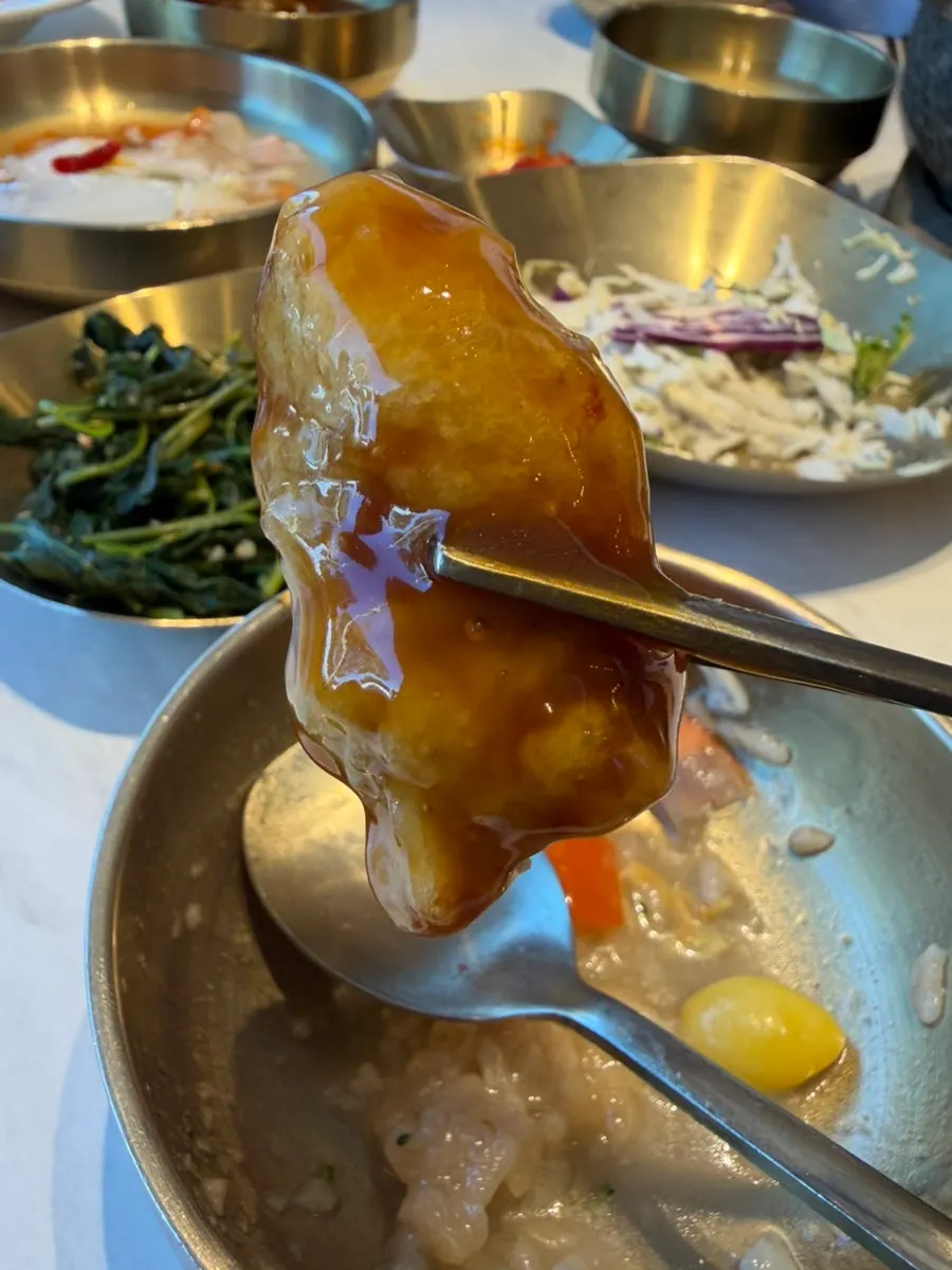 Dipping tangsuyuk into the sauce