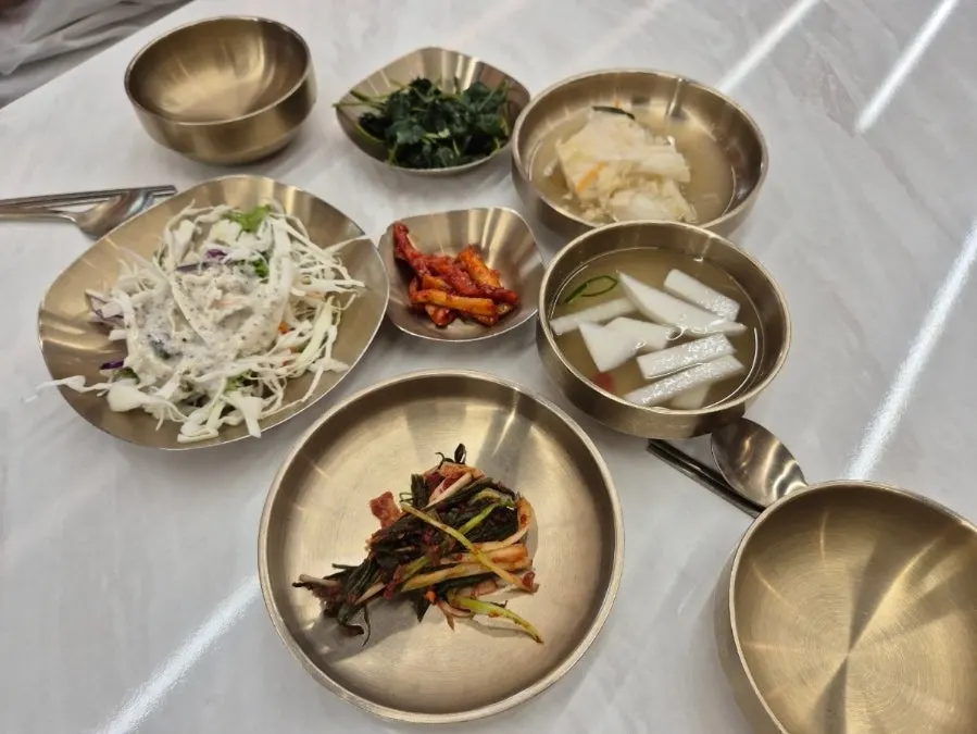 A full spread of side dishes served in brass bowls