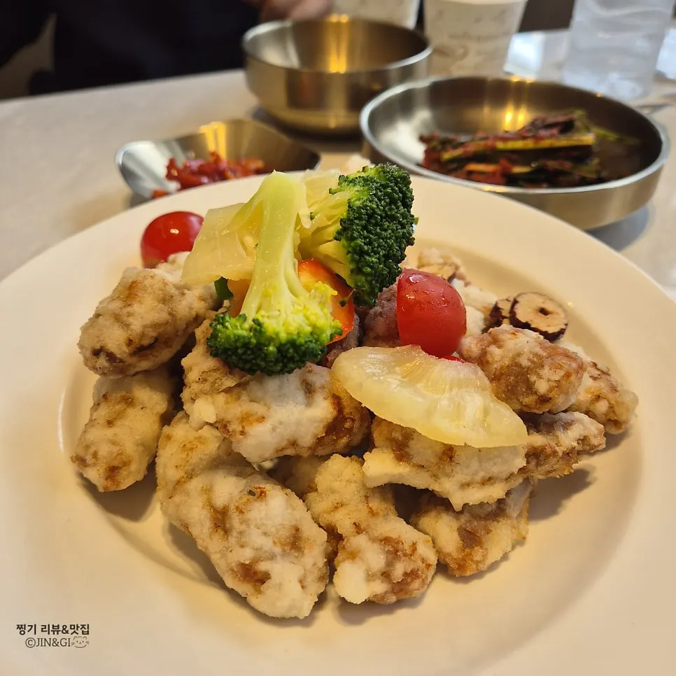 Plate of tangsuyuk topped with broccoli and pineapple garnish