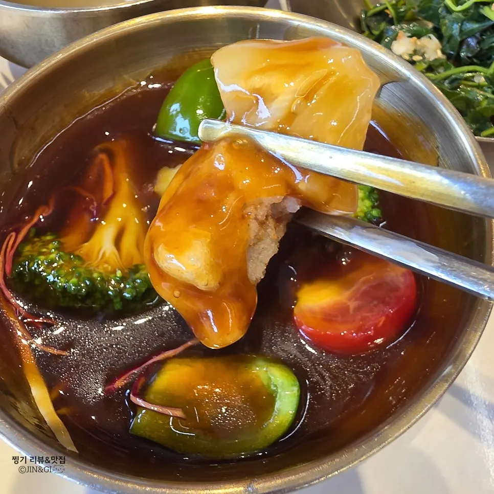 A piece of tangsuyuk being picked up with chopsticks