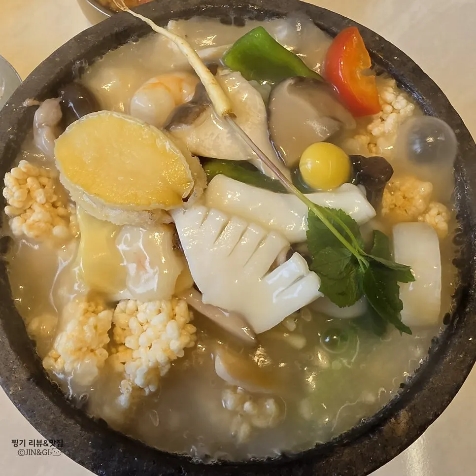Seafood abalone rice soup topped with a whole abalone and wild ginseng sprouts