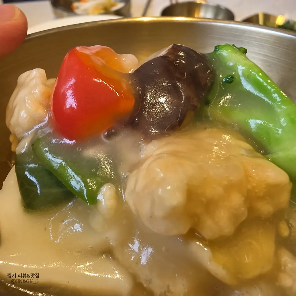 A spoonful of seafood and scorched rice scooped from the bowl