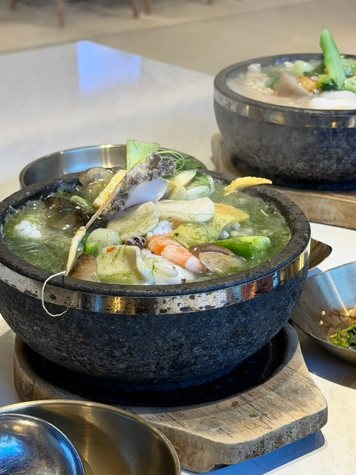 The moment the nurungjitang broth is poured into the hot stone pot