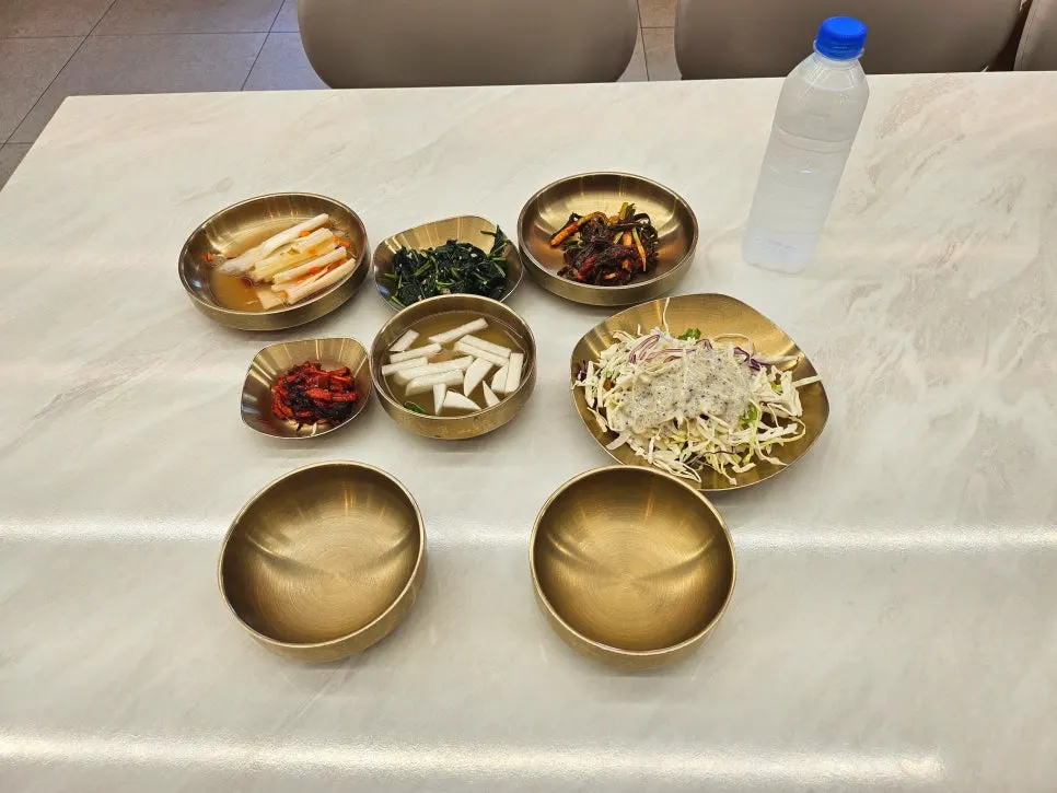 A full spread of side dishes served in brass bowls