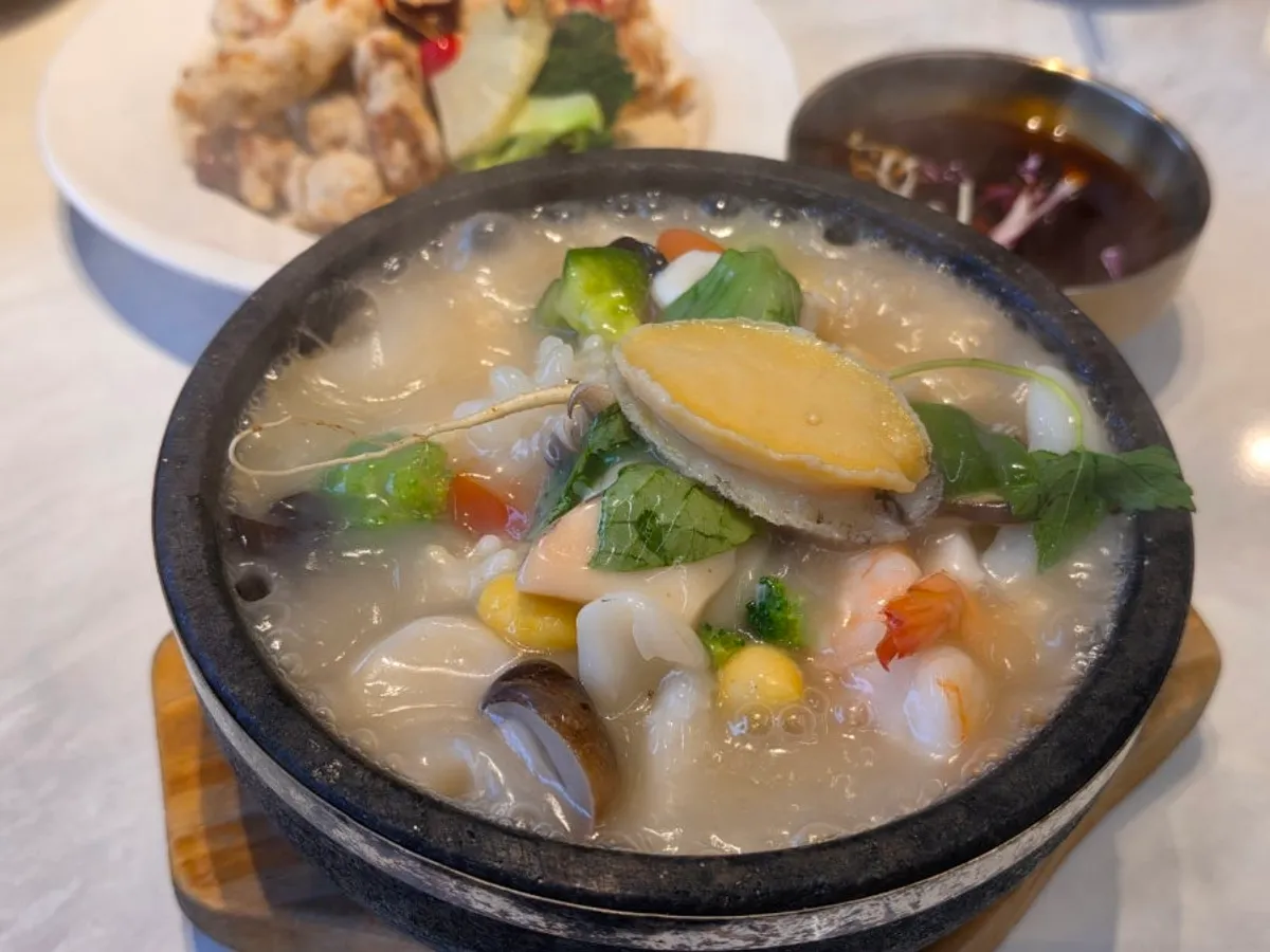 Table spread with seafood abalone rice soup and fresh tenderloin tangsuyuk