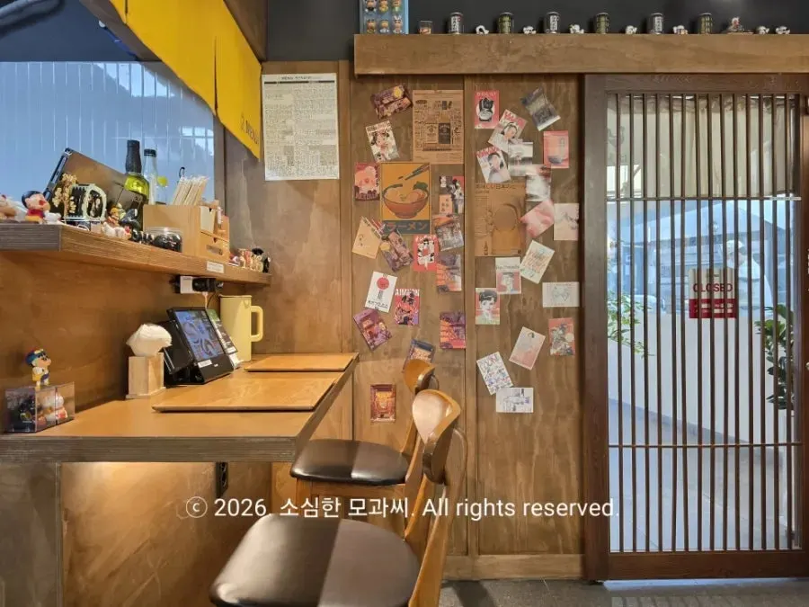 Interior of Menji Hanam Misa Branch with bar table and table seating