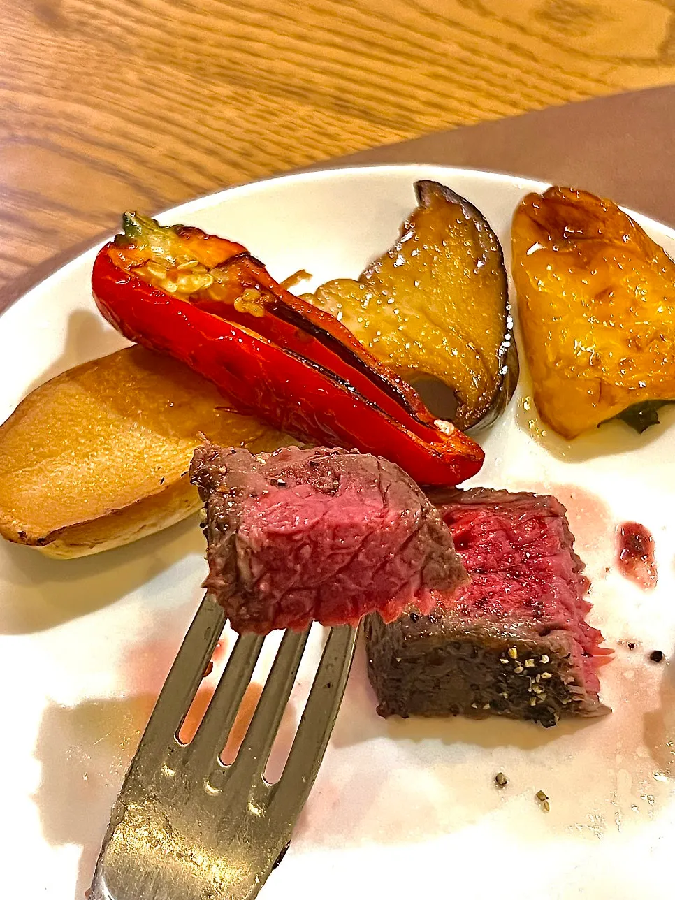 A bite of steak with grilled vegetables