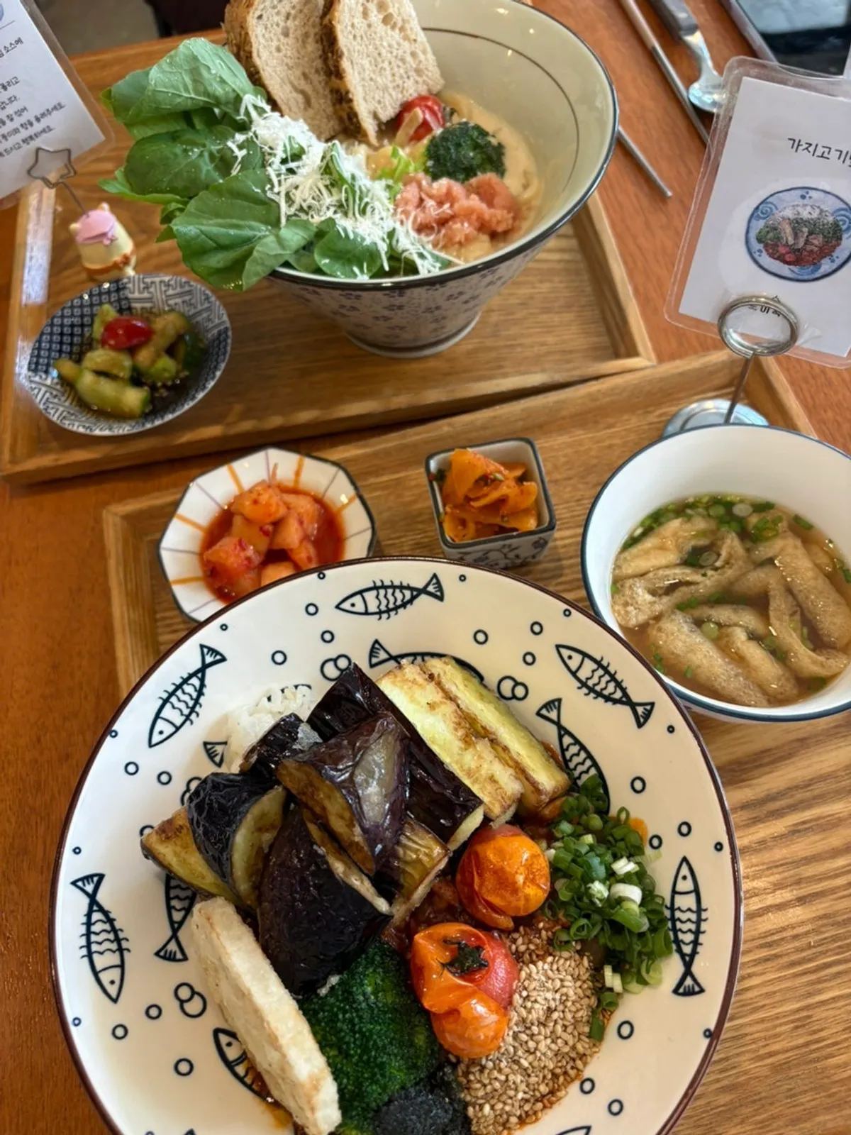 Table setting with eggplant tempura meat rice bowl and cream mentaiko pasta