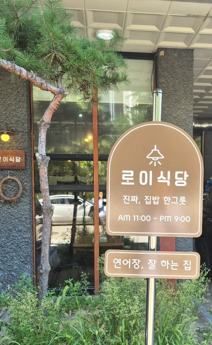 Signboard with business hours and signature menu phrases