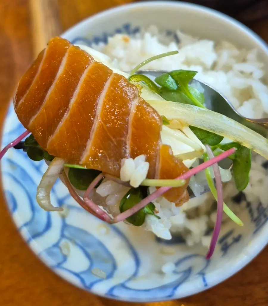A spoonful of rice topped with salmon jang