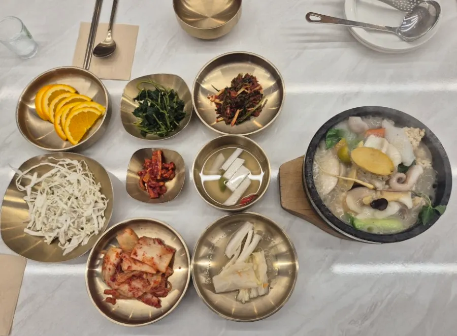Table set with nurungjitang, cabbage kimchi, and oranges