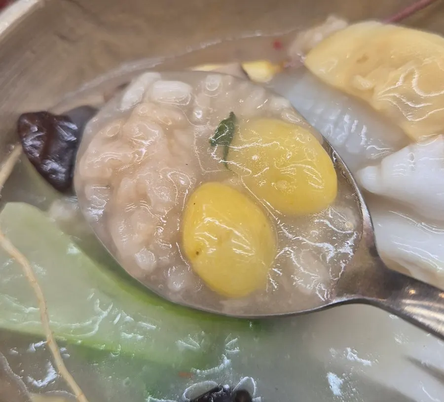 A spoonful of scorched rice softened in the broth