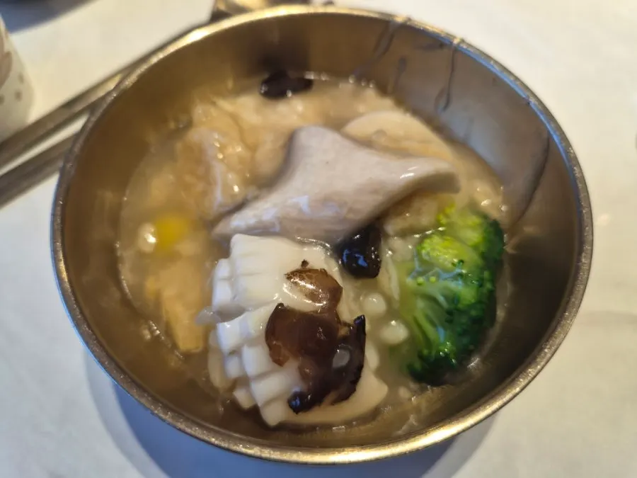 A bowl of seafood nurungjitang with the rice softened into the broth