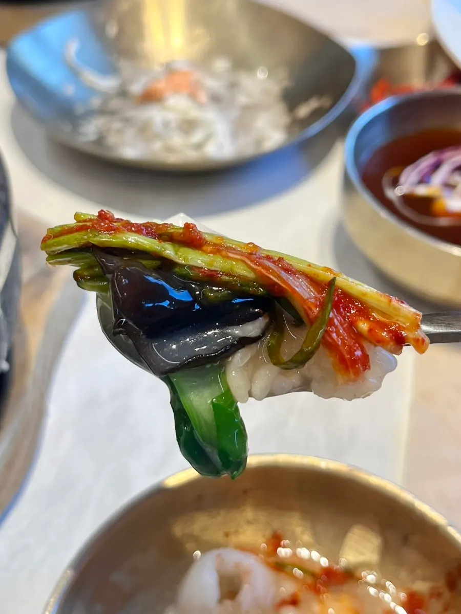 A spoonful of nurungjitang showing the seafood's sweetness