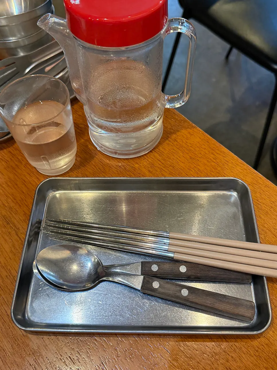 Menu dan botol air bertutup merah di atas meja