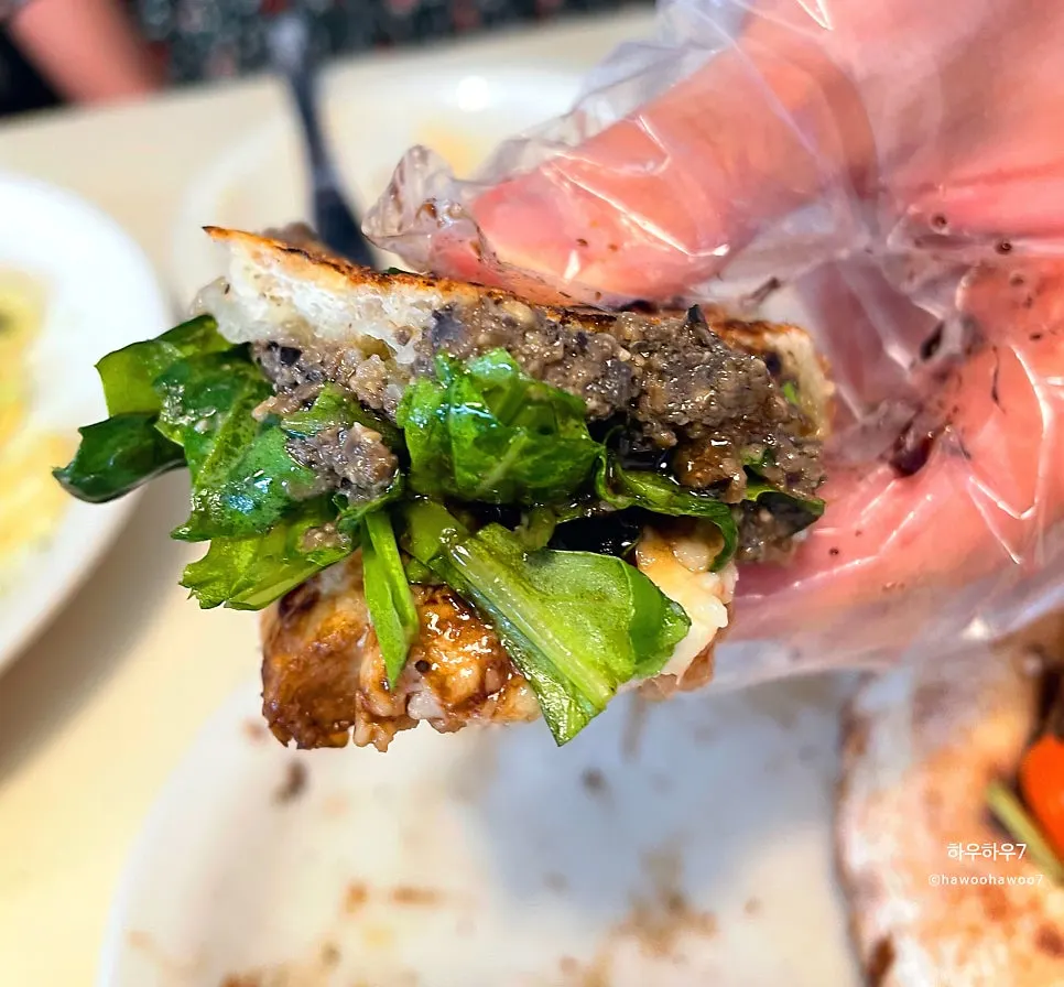 Close-up of the pizza boat with arugula and black olives