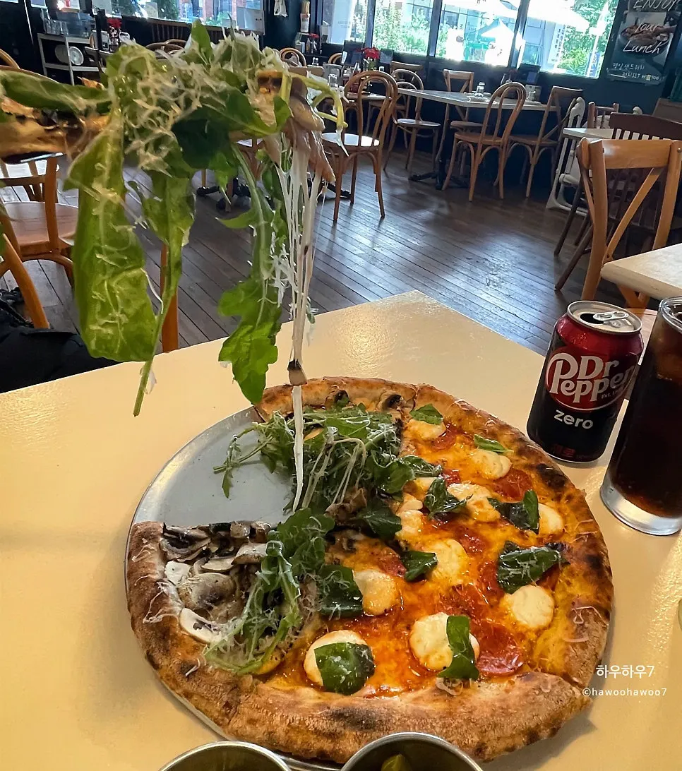 A slice of truffle mushroom pizza topped with arugula