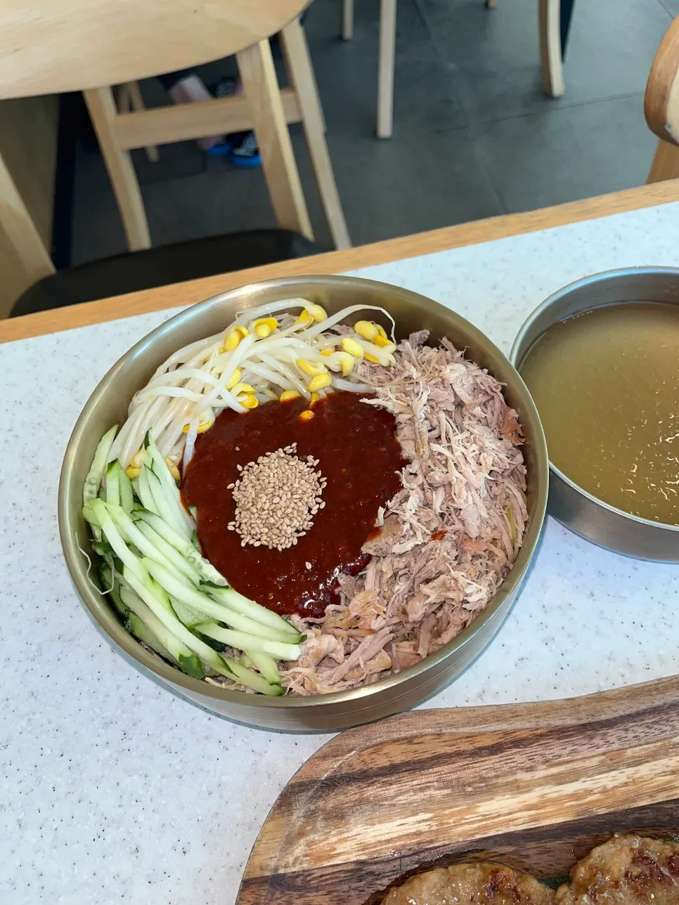 Extra-large dongchimi bibim noodles topped with cucumber and meat