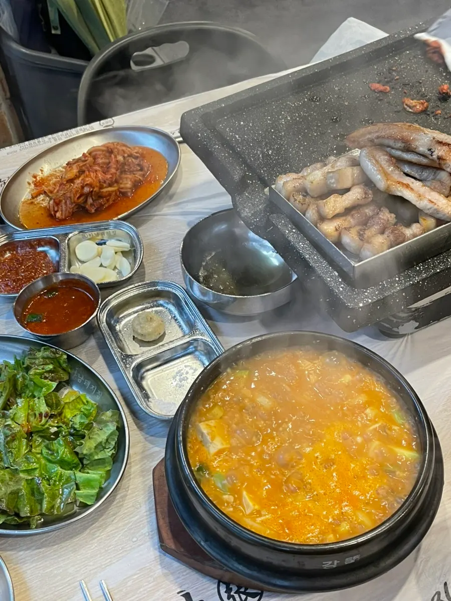 Grilled pork belly moved to the metal dish alongside stir-fried kimchi