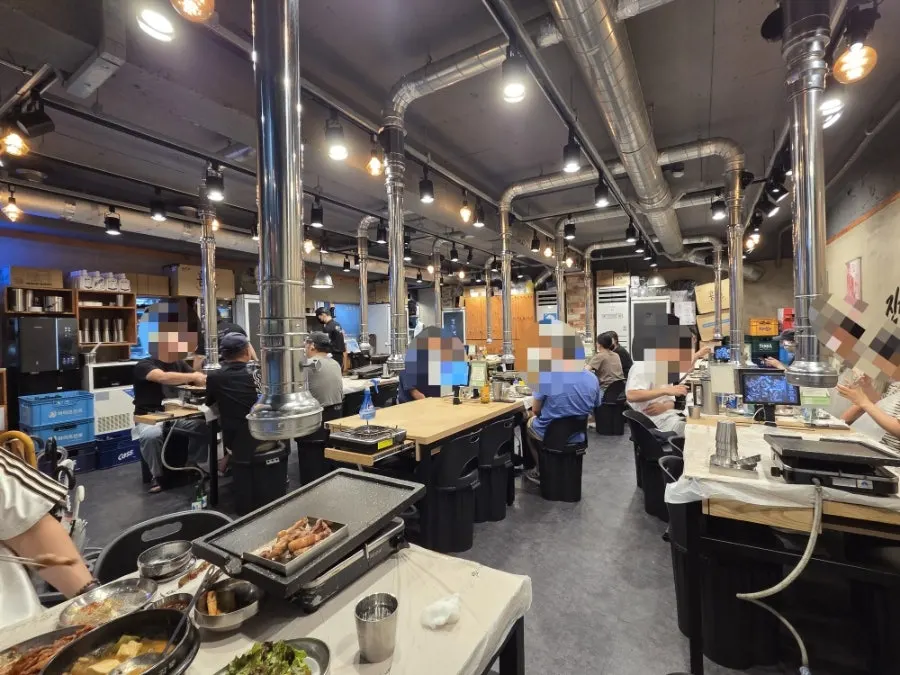 Tables inside Hanam Doeji Jip Seokgye branch on a Friday evening