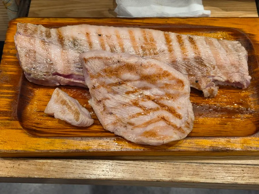 Pre-seared pork belly and pork jowl set beside the stone griddle