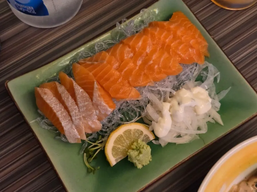 Salmon sashimi served with onions and sauce