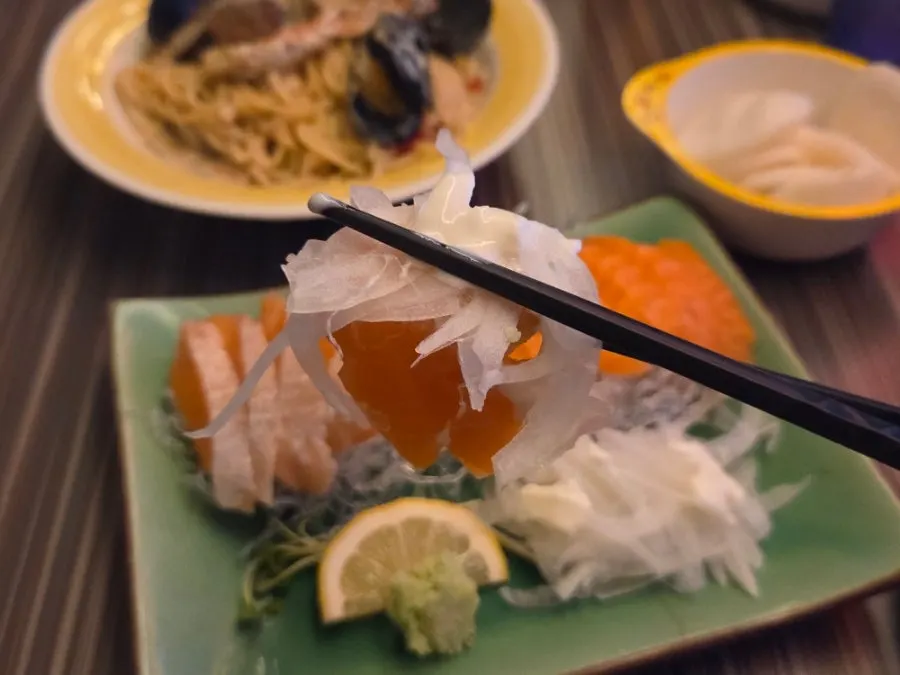 Salmon sashimi paired with onions and sauce