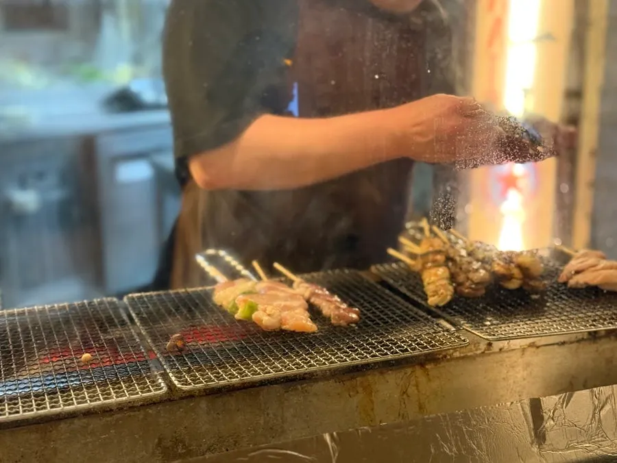 Charcoal yakitori grilling behind the smoke screen