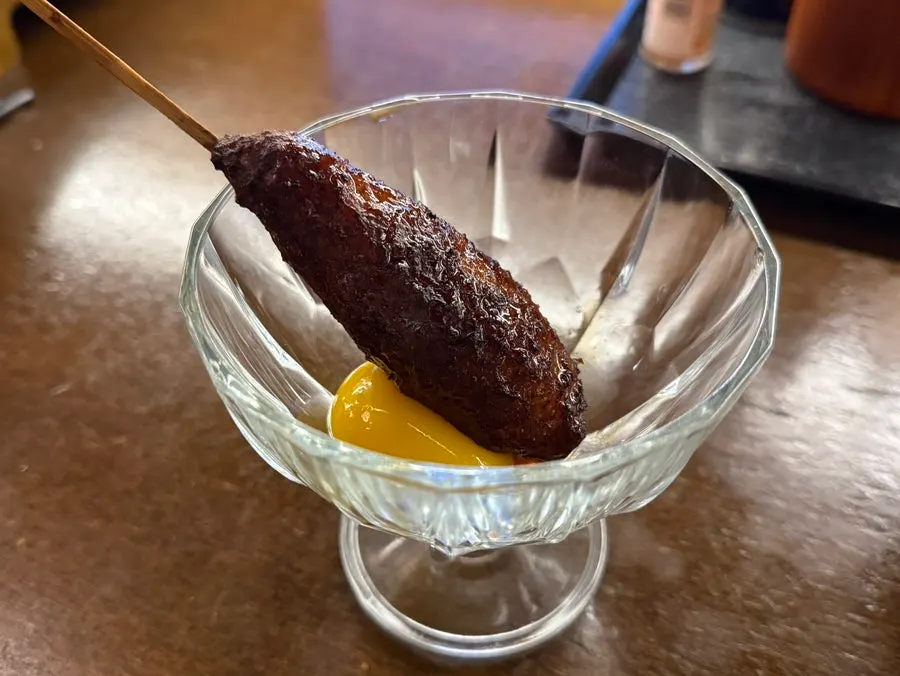 Tsukune skewer served with egg yolk