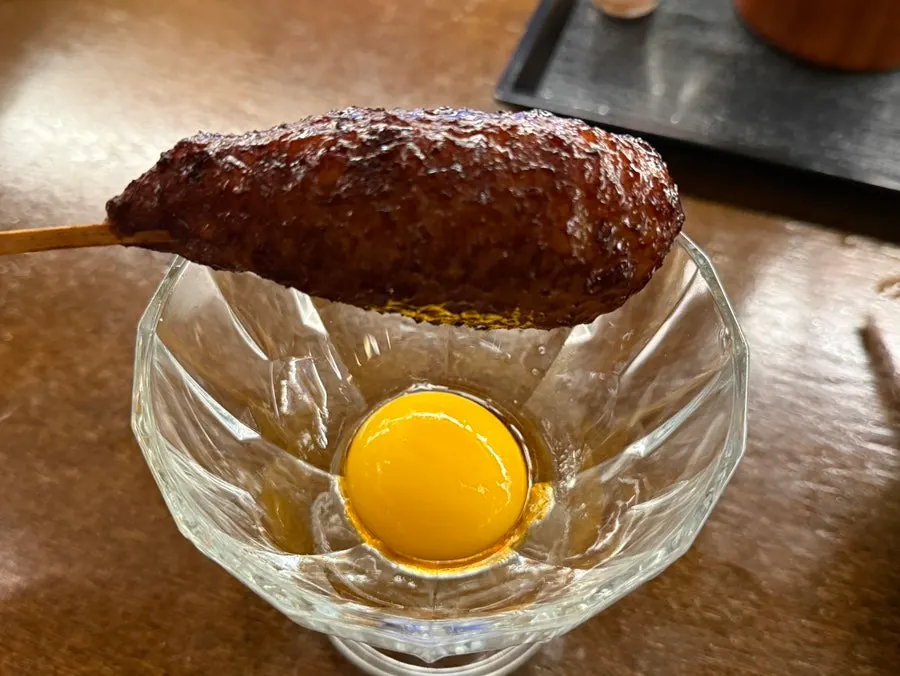 Cross-section of tsukune dipped in sauce