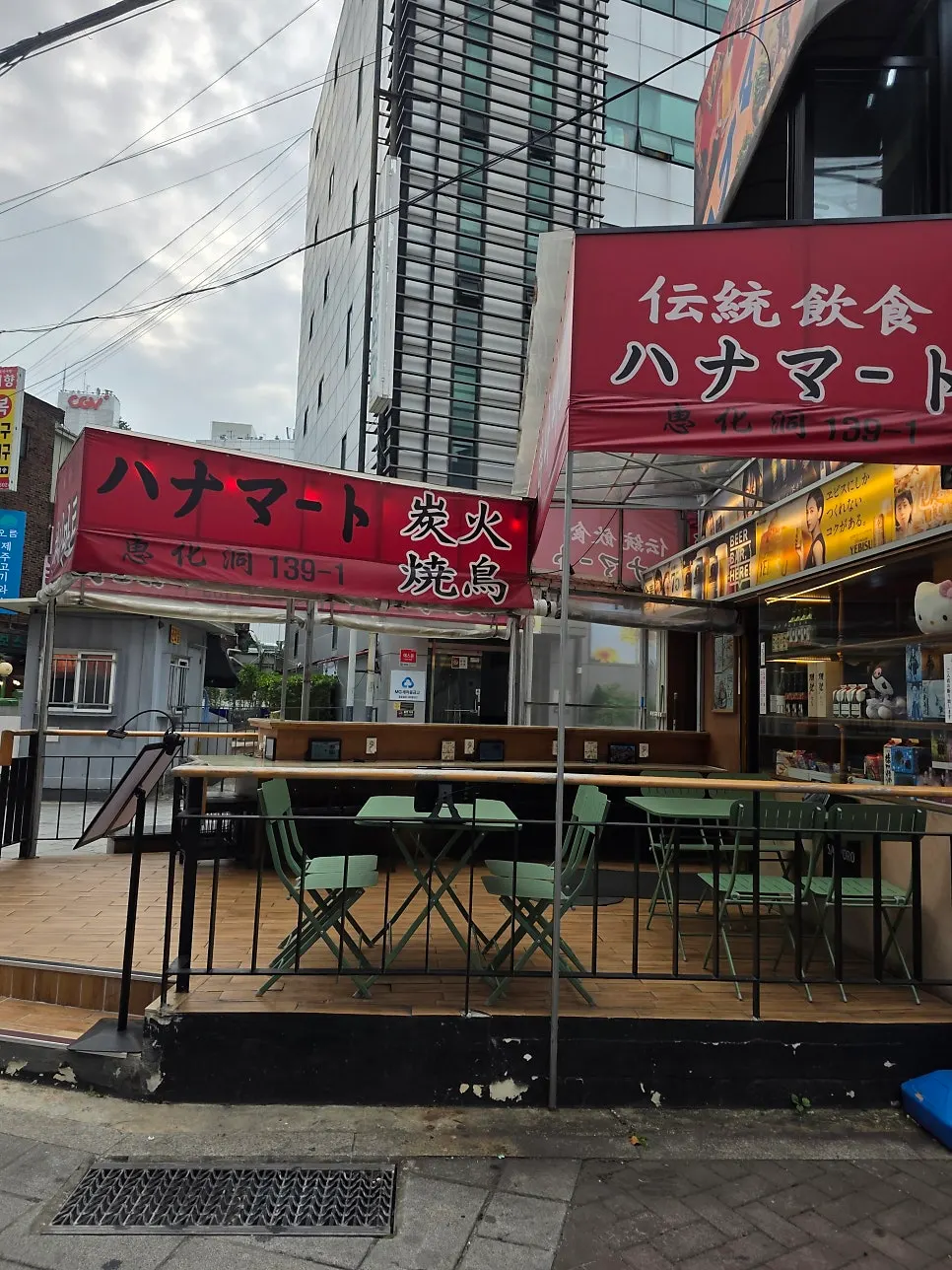 Mint-colored outdoor tables in front of Hanamato's entrance