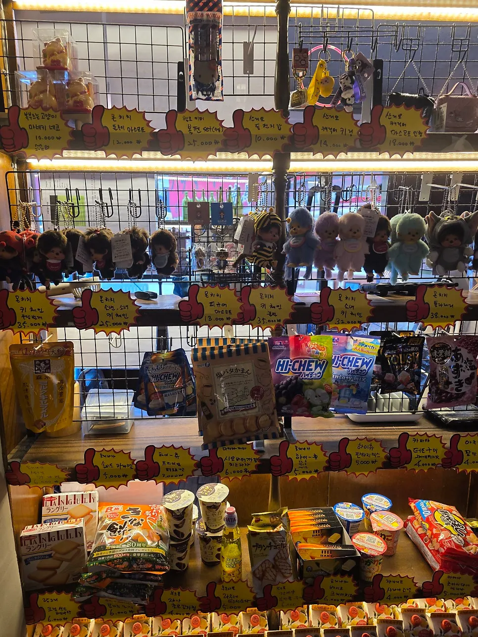 Shelf display of Monchhichi keychains and Japanese snacks