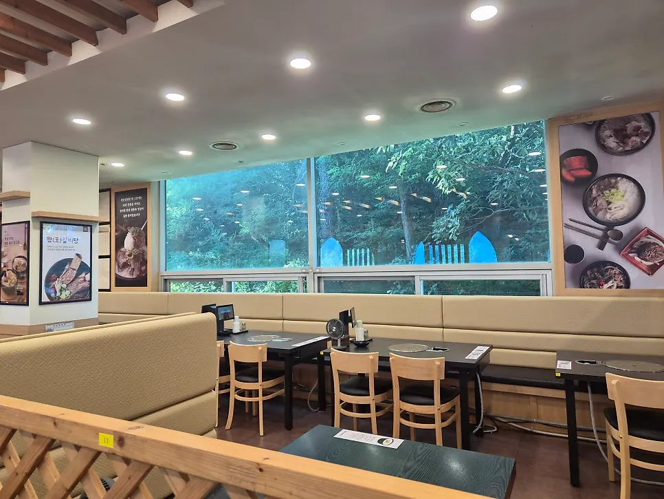 Spacious restaurant interior with a green view through the windows
