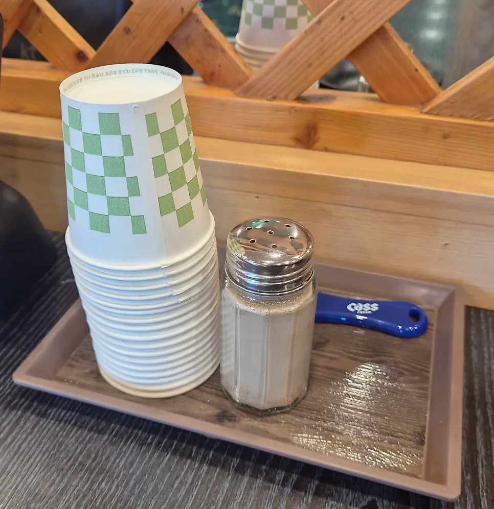 Table set with paper cups and pepper