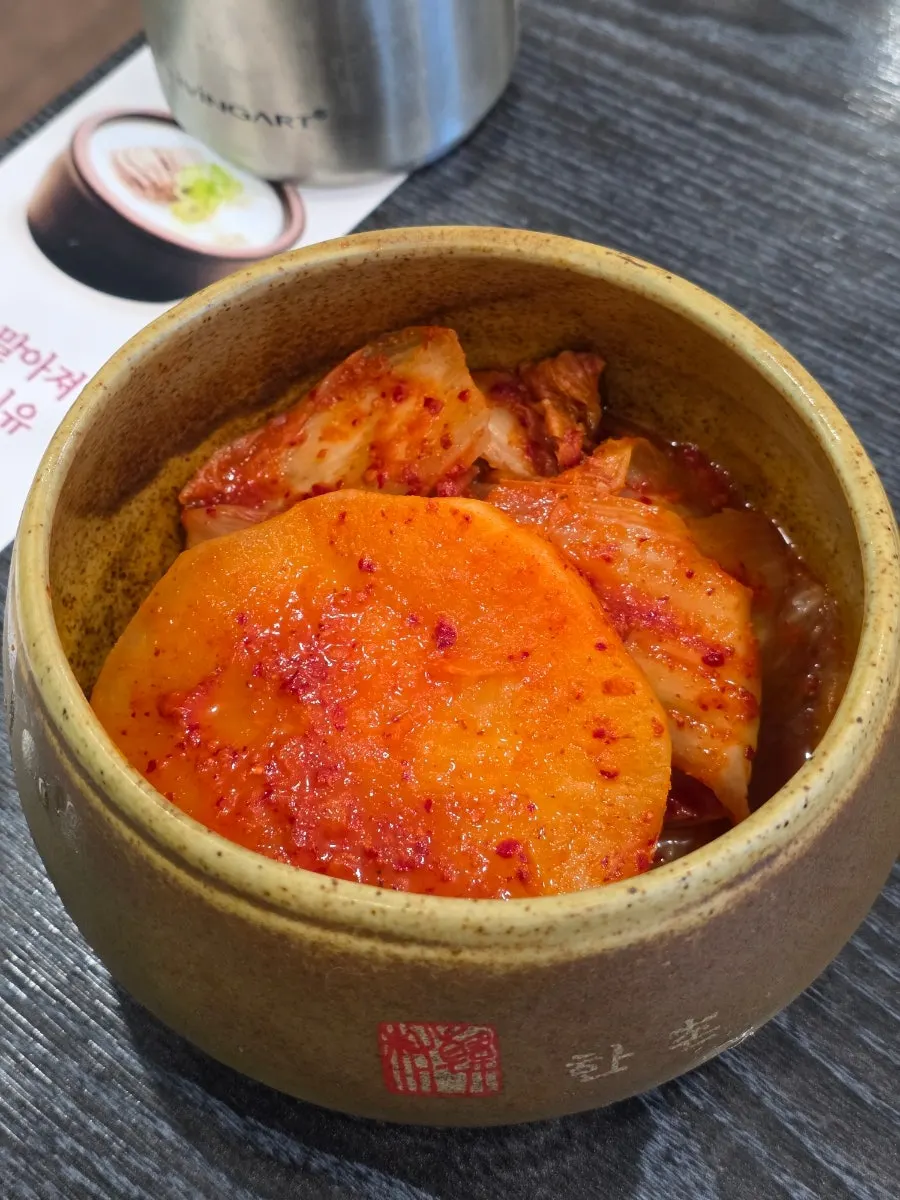 Basic side dishes of diced radish kimchi and napa cabbage kimchi served in a crock