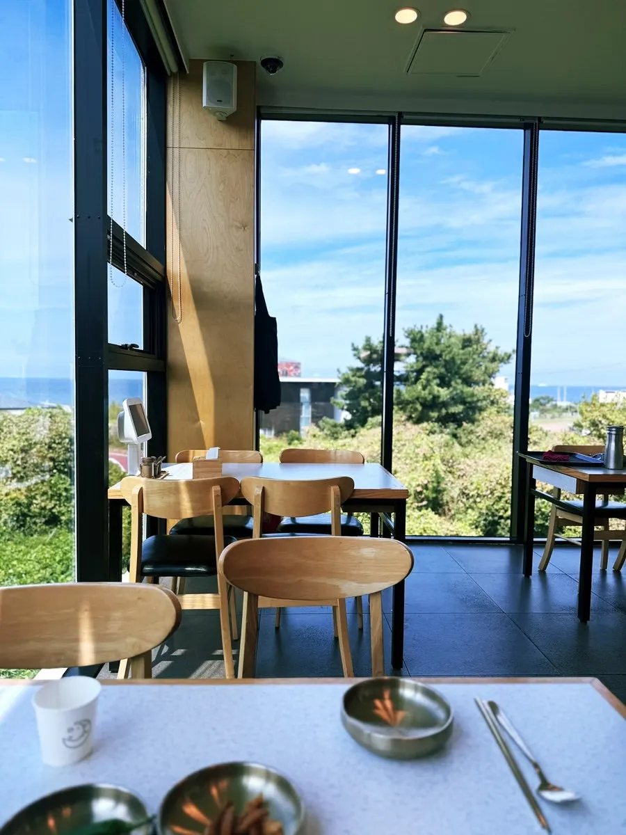 Interior of Handam Guksu with the sea visible through the floor-to-ceiling window