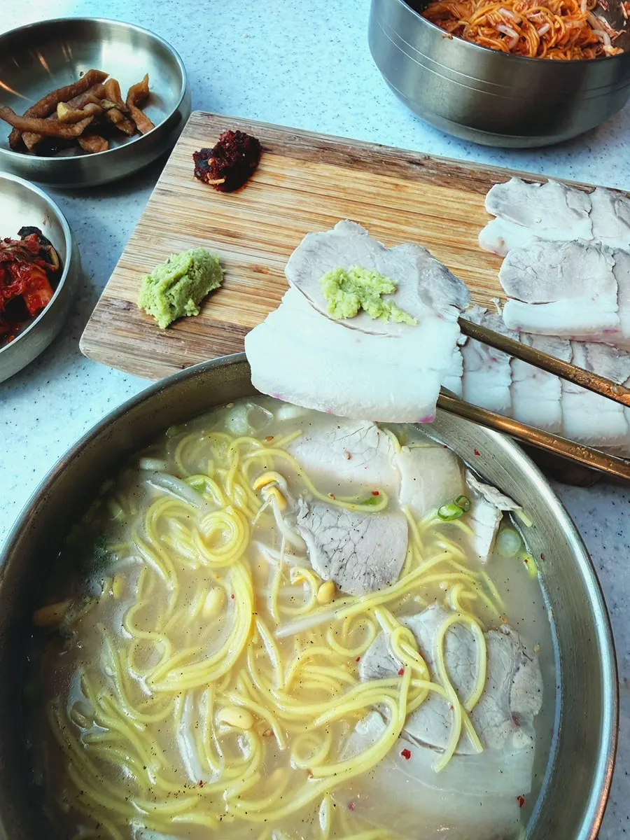 A bowl of Handam Guksu's rich bone broth pork noodles
