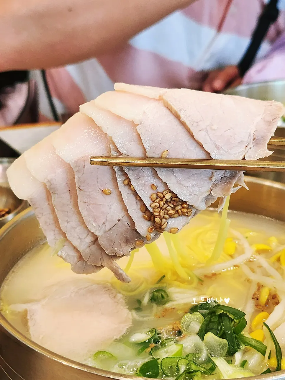 Noodles lifted with chopsticks from the pork noodle soup
