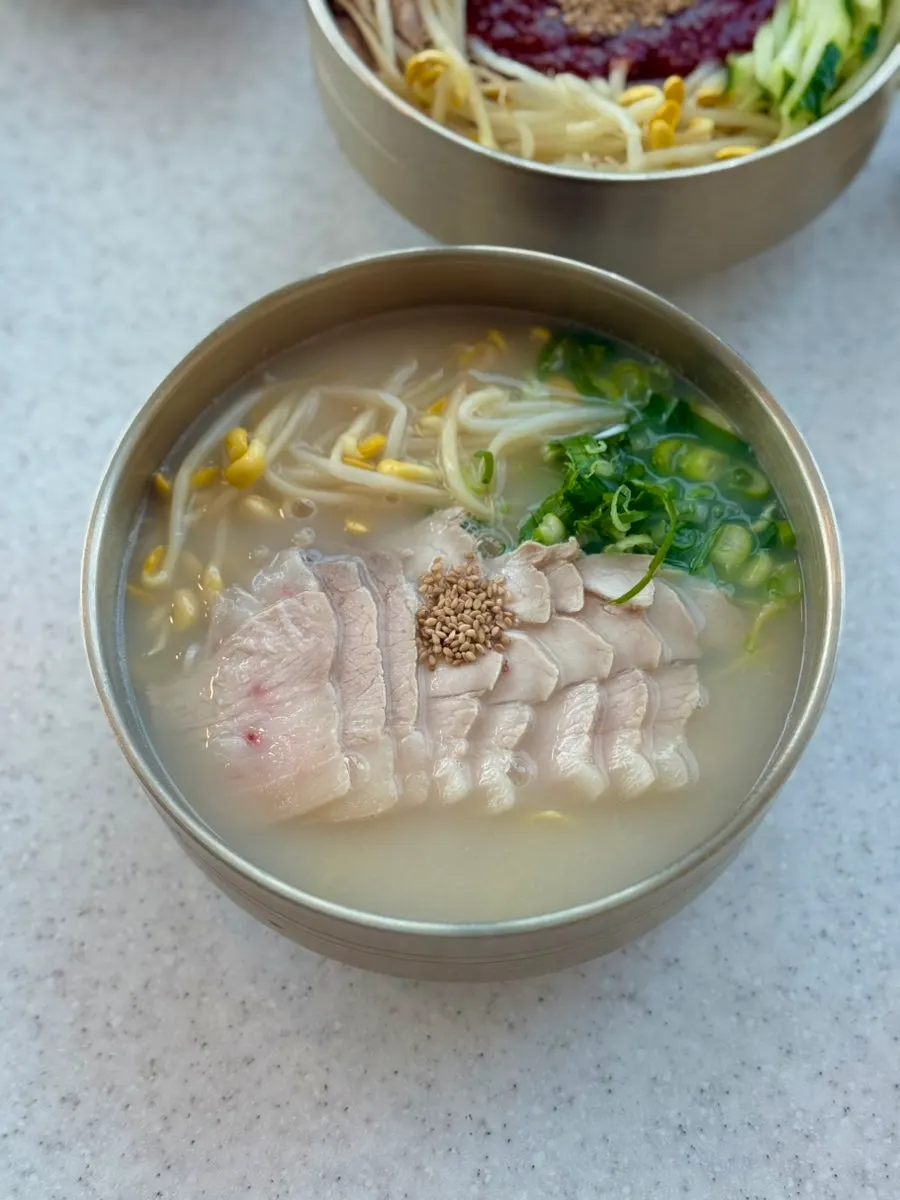 Table set with both pork noodle soup and bibim noodles