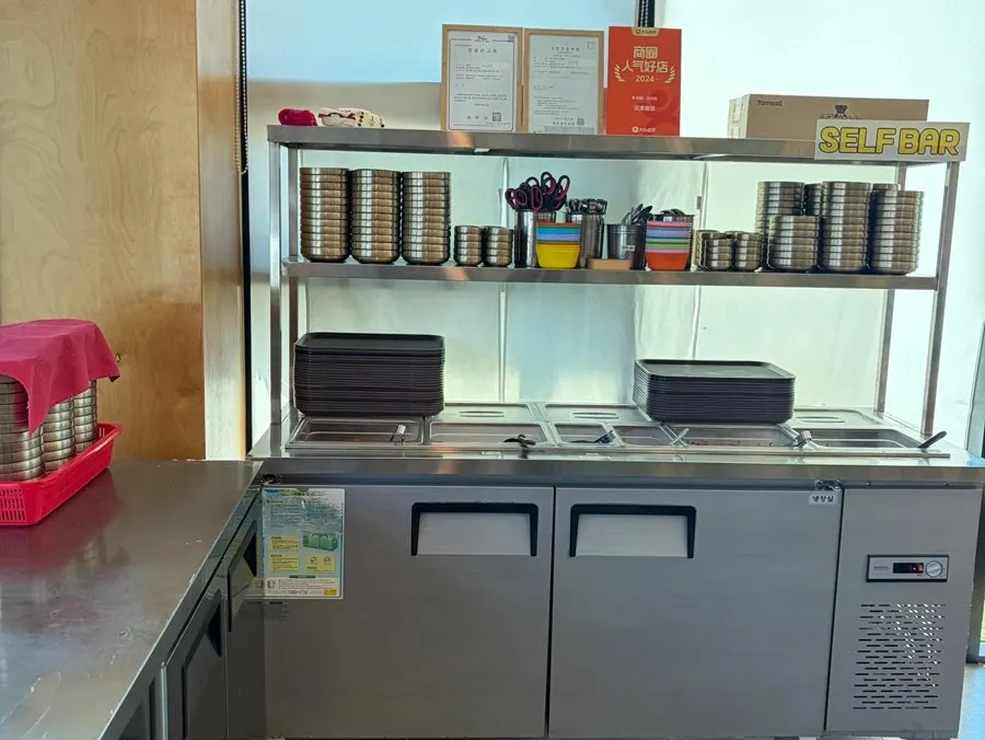 Self-serve bar with utensils, small plates, and side dishes