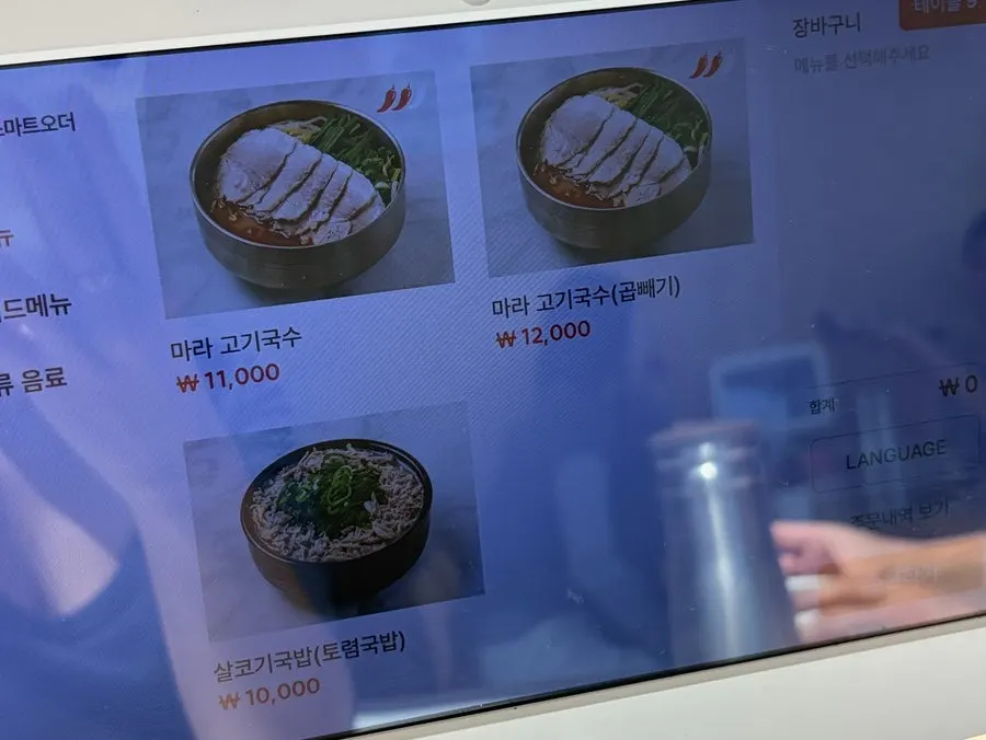 Menu listing prices for bone-broth pork noodle soup and bibim noodles