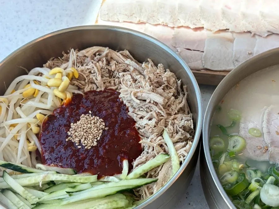 Dongchimi bibim noodles with bean sprouts, cucumber, and chicken topping
